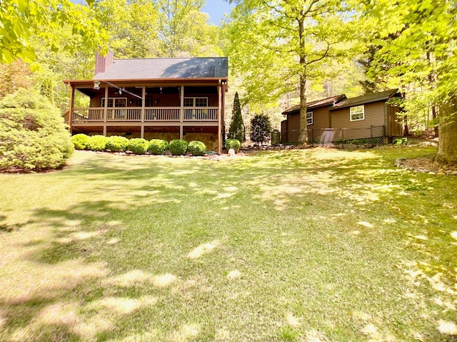 rear view of house featuring a lawn, a deck, and a chimney