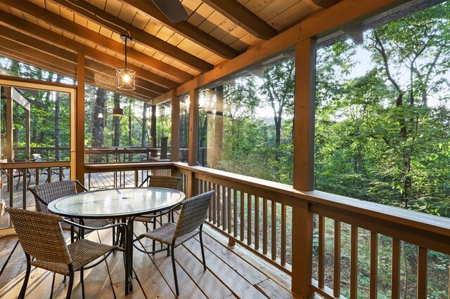 sunroom featuring vaulted ceiling with beams, wooden ceiling, and a wealth of natural light