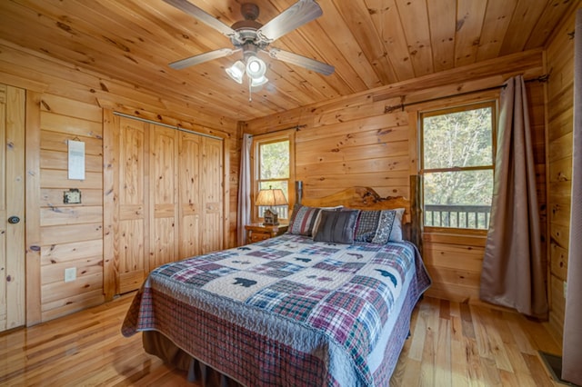 bedroom featuring light wood-type flooring, ceiling fan, wood walls, and wooden ceiling