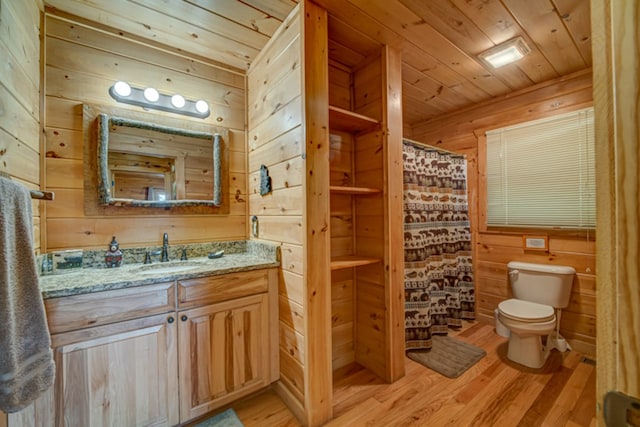 bathroom featuring hardwood / wood-style floors, wood ceiling, vanity, toilet, and wood walls