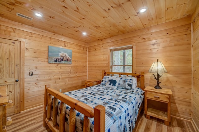 bedroom featuring wood walls and light hardwood / wood-style flooring