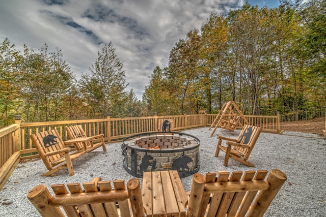 wooden deck with a patio area and an outdoor fire pit