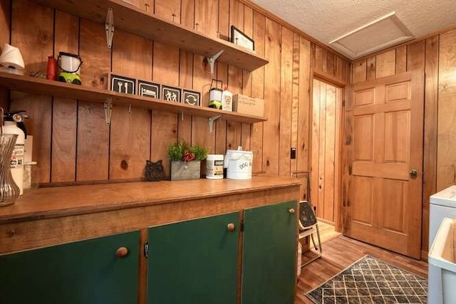 bar featuring wood walls, a textured ceiling, and wood finished floors