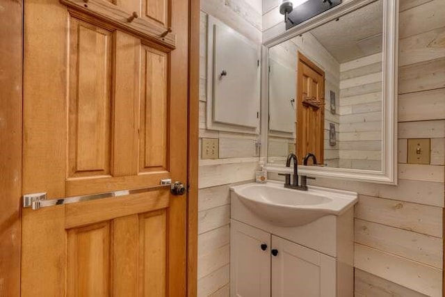 bathroom featuring wood walls and vanity