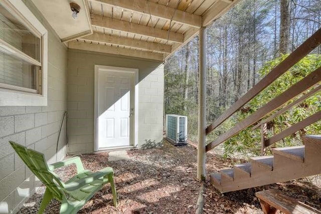 entrance to property featuring central air condition unit and concrete block siding