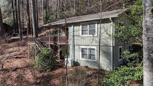 view of side of property featuring stairway and a wooden deck