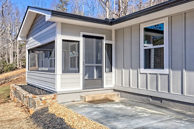 view of exterior entry with a patio area