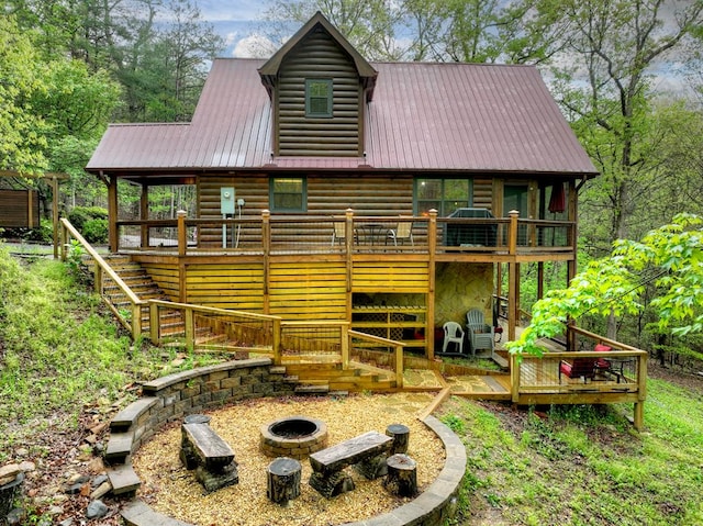 rear view of house with a fire pit, stairway, metal roof, and a wooden deck