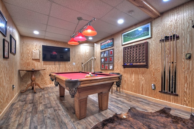 rec room with wood finished floors, baseboards, pool table, a paneled ceiling, and wood walls