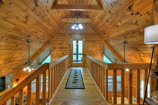corridor featuring wooden ceiling, wood-type flooring, wooden walls, and a chandelier