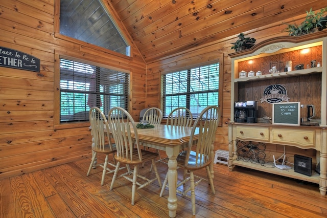 dining room featuring wood walls, vaulted ceiling, hardwood / wood-style floors, and wood ceiling