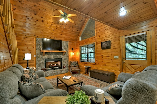 living area with wooden ceiling, a ceiling fan, wooden walls, a fireplace, and lofted ceiling