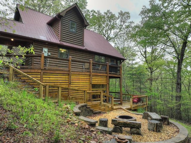 back of property featuring log veneer siding, metal roof, a deck, and stairway