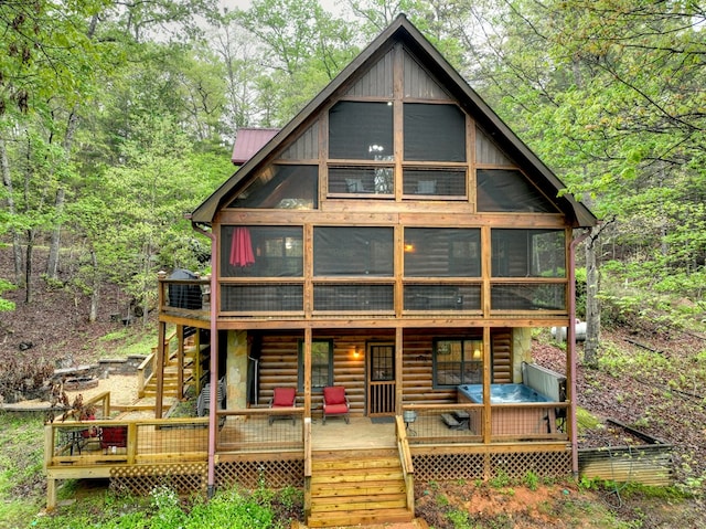 back of property with a sunroom, stairs, and a deck