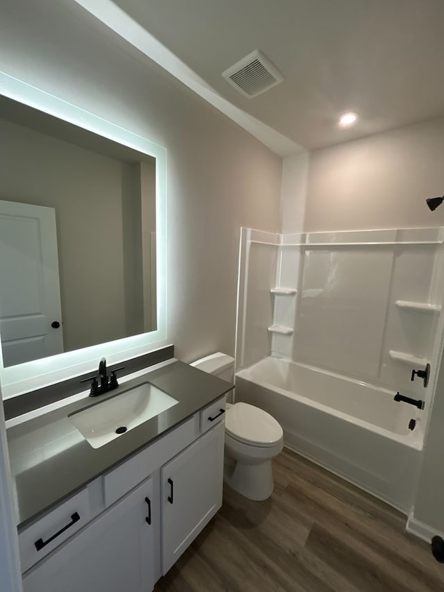 full bathroom with vanity, hardwood / wood-style floors,  shower combination, and toilet