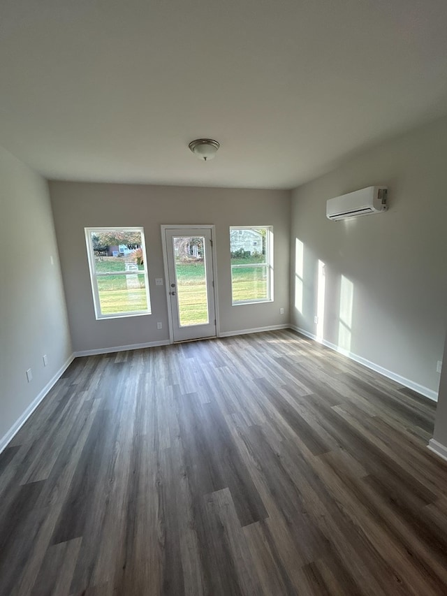 interior space featuring a wall mounted air conditioner and dark hardwood / wood-style floors