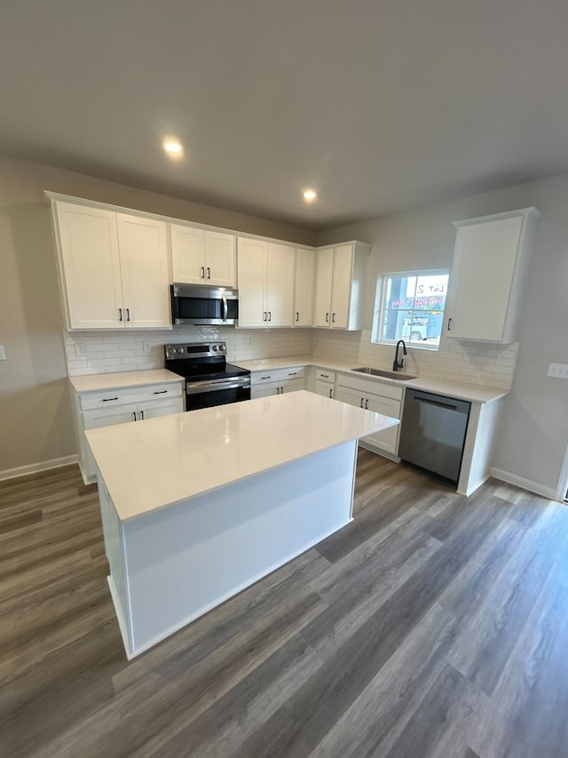 kitchen featuring white cabinetry, dark hardwood / wood-style flooring, a kitchen island, and appliances with stainless steel finishes