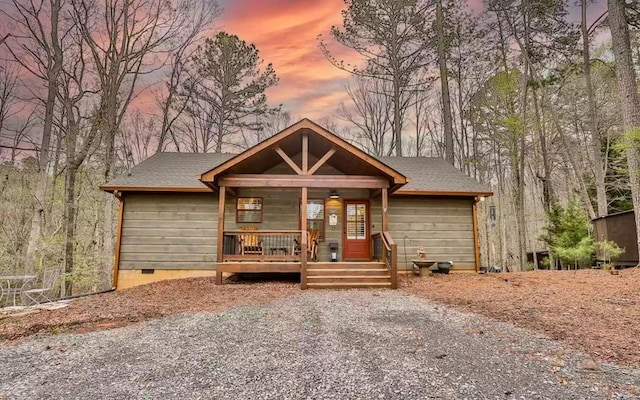 view of front of home featuring a shingled roof, crawl space, and covered porch