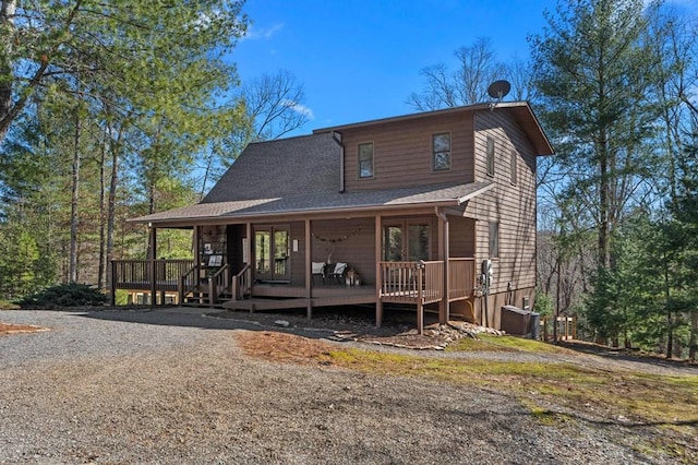 rear view of house featuring a shingled roof and a deck