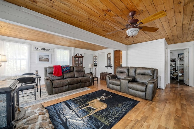 living room with hardwood / wood-style floors, wooden ceiling, wood walls, and a healthy amount of sunlight