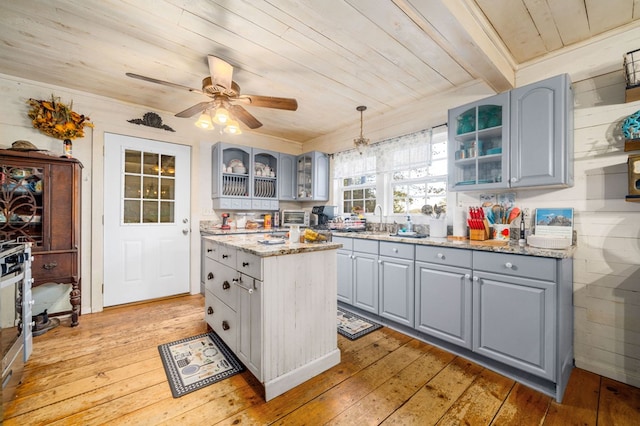 kitchen featuring gray cabinets, light hardwood / wood-style flooring, and decorative light fixtures