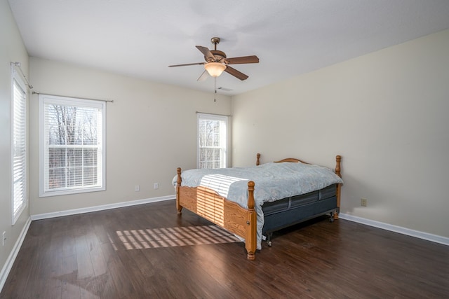 bedroom featuring multiple windows, dark hardwood / wood-style floors, and ceiling fan