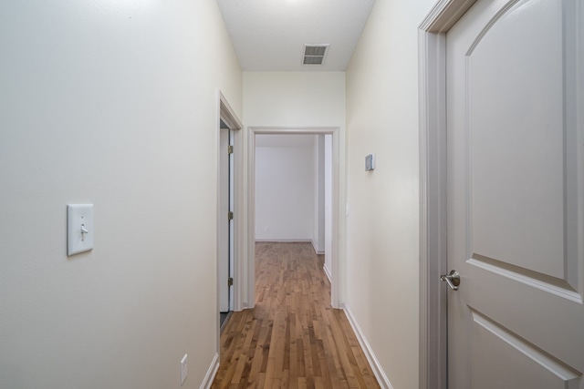 hallway featuring hardwood / wood-style flooring and a textured ceiling