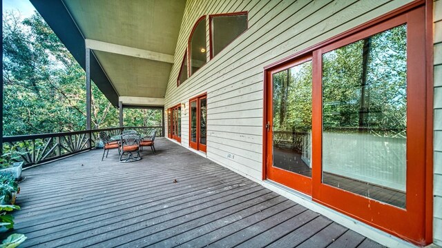 wooden terrace with outdoor dining area and french doors