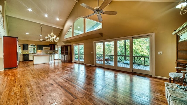 unfurnished living room featuring french doors, wood finished floors, and ceiling fan with notable chandelier