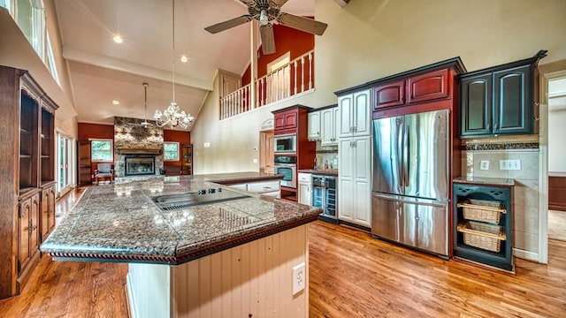 kitchen featuring high vaulted ceiling, appliances with stainless steel finishes, wine cooler, and light wood-type flooring