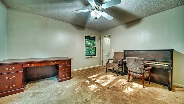 carpeted home office with ceiling fan, a textured ceiling, and baseboards