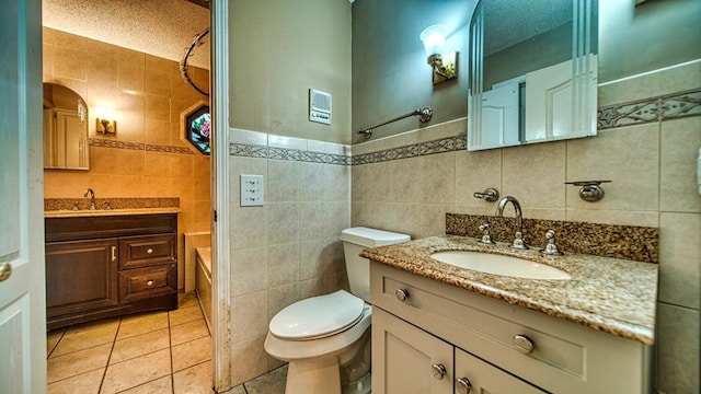 bathroom featuring toilet, tile patterned flooring, tile walls, and vanity