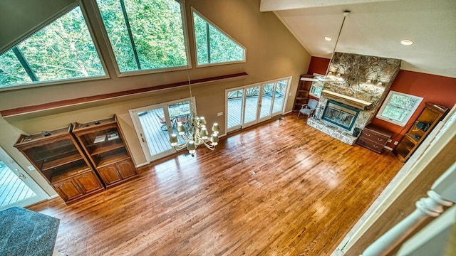 living room featuring crown molding, a fireplace, high vaulted ceiling, and wood finished floors