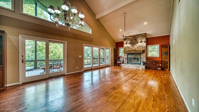 unfurnished living room with beam ceiling, a fireplace, wood finished floors, high vaulted ceiling, and ceiling fan with notable chandelier