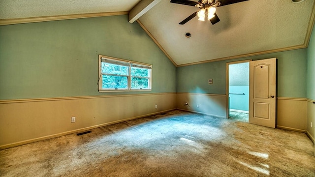 carpeted spare room featuring lofted ceiling with beams, crown molding, visible vents, and a textured ceiling