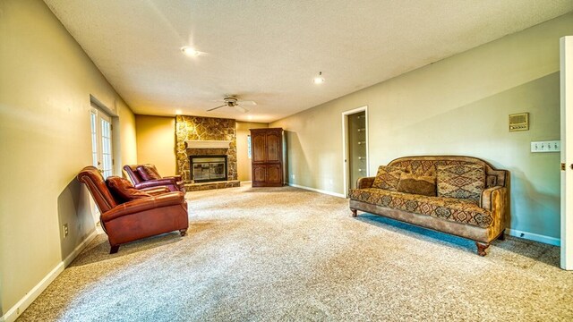 interior space with a textured ceiling, a fireplace, a ceiling fan, and baseboards