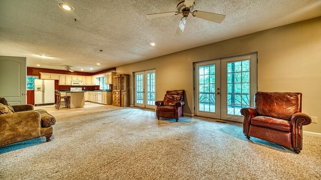 sitting room featuring light carpet, ceiling fan, baseboards, and french doors