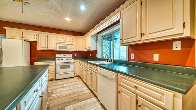 kitchen with a textured ceiling, white appliances, a sink, wood tiled floor, and dark countertops