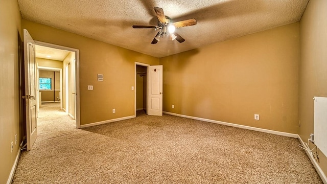 unfurnished bedroom featuring a textured ceiling, carpet flooring, and baseboards