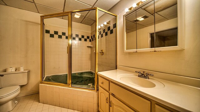 bathroom featuring baseboards, toilet, tile patterned floors, tiled shower / bath, and vanity