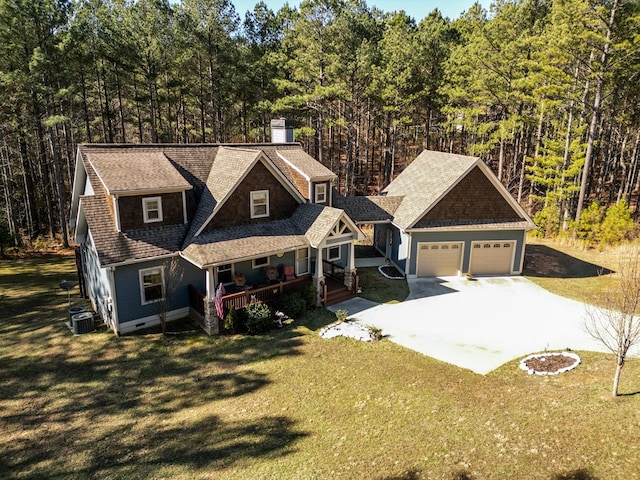 view of front of property with a garage, a front yard, covered porch, and cooling unit