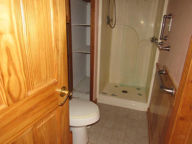 bathroom with toilet and walk in shower