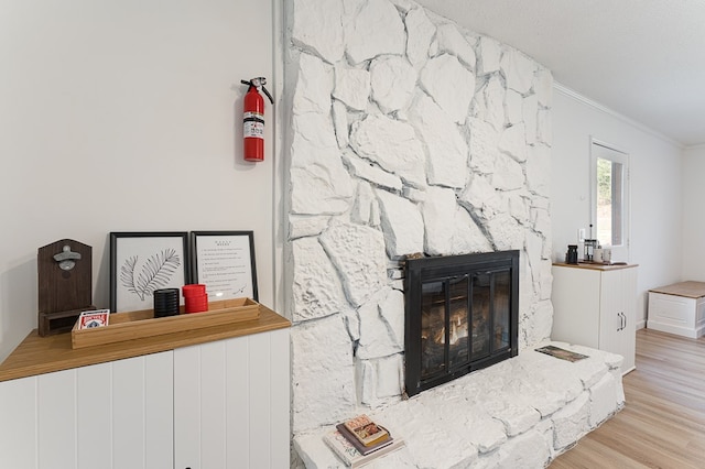 details with a stone fireplace, wood-type flooring, and crown molding