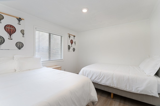 bedroom with ornamental molding and hardwood / wood-style flooring