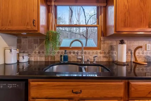 kitchen featuring black dishwasher, sink, and backsplash