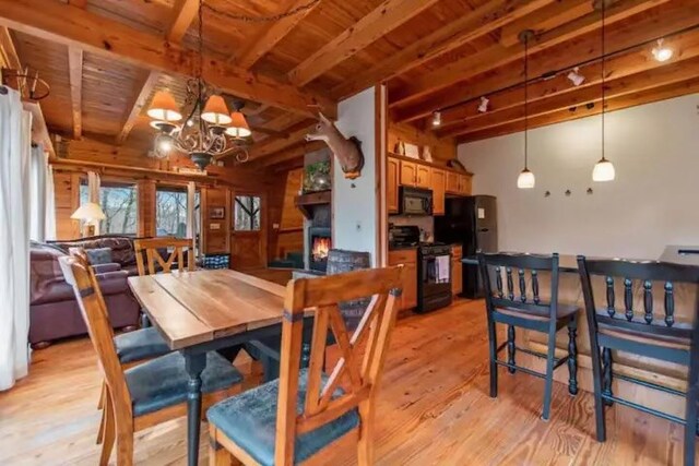 dining space featuring light hardwood / wood-style flooring, a chandelier, beamed ceiling, and wooden ceiling