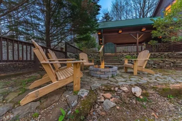 view of patio featuring a wooden deck and a fire pit