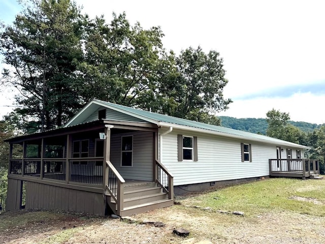 exterior space with a wooden deck and a lawn