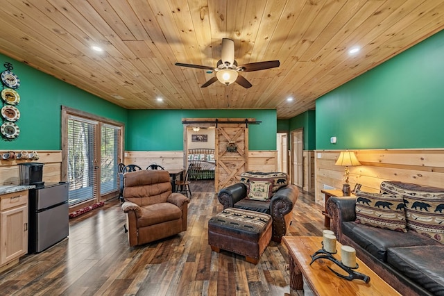 living area featuring wooden ceiling, a barn door, dark wood-type flooring, and wainscoting