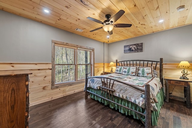 bedroom featuring wooden ceiling, wooden walls, dark wood-type flooring, visible vents, and wainscoting